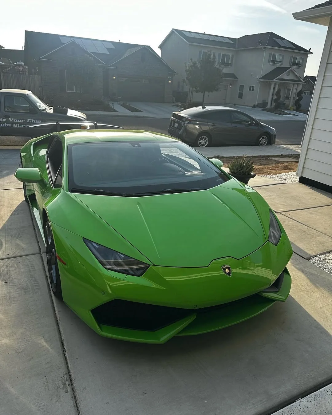 Green Lamborghini Huracan with newly replaced glass outside a customer home